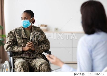 Focused Black Female Soldier In Wheelchair Engaged In Conversation With Therapist At Office, Promoting Healthcare And Support Services For Veterans In Need Of Assistance. 143506537