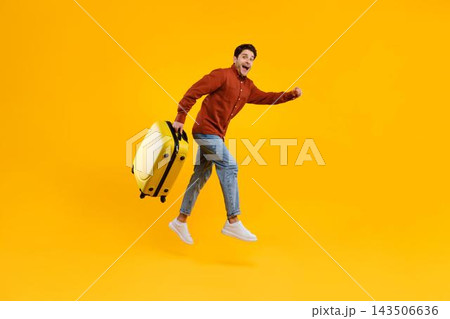 Joyful Male Appearing Happy While Running With Yellow Suitcase, Energized And Excited, In Bright Studio Setting. Travel Concept, Adventure Mood, Preparing For Upcoming Journey. 143506636
