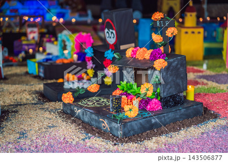 Flower garland and RIP cross on a handmade Mexican Day of the Dead miniature tomb 143506877