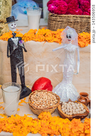 Decorative skeleton bride and groom among Mexican Day of the Dead offerings. 143506958