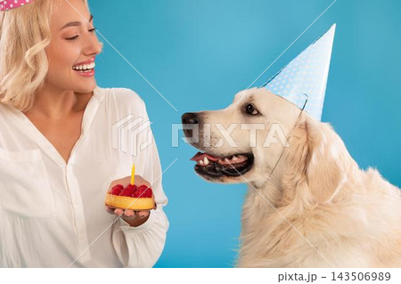 Smiling Young Woman Celebrating Happy Birthday For Her Dog. Holding Cake With Candle In Outdoor Setting, Dog Wearing Party Hat. Joyful Moment Filled With Love And Happiness. Smiling Young Woman Celebrating Happy Birthday For Her Dog. Holding Cake With Candle In Outdoor Setting, Dog Wearing Party Hat. Joyful Moment Filled With Love And Happiness. 143506989