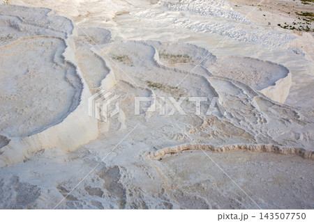 White travertine terraces in Pamukkale, Turkey during daylight in a warm outdoor setting White travertine terraces in Pamukkale, Turkey during daylight in a warm outdoor setting 143507750