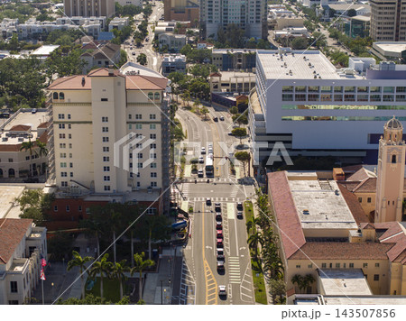 Lively Sarasota street scene shows pedestrians stepping onto the crosswalk while automobiles line up at the stop signal, emphasizing city infrastructure and traffic rules. 143507856