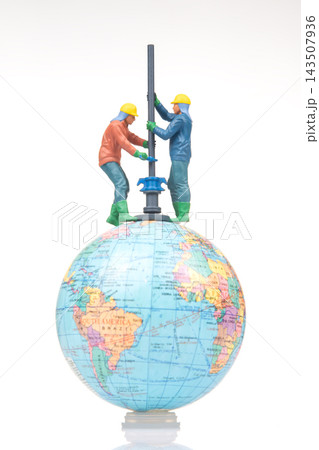 Miniature figures working on globe with tools and equipment Miniature figures working on globe with tools and equipment 143507936
