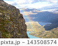 Colors in the sky appear above mountains and a lake in Norway during a sunny day 143508574
