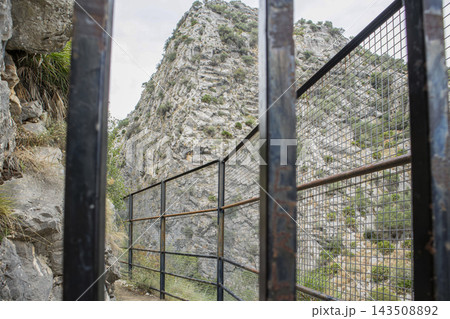 Protective metal safety fence along a steep hiking trail in the mountains 143508892
