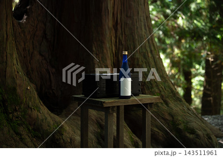 古木の前に供えられた日本酒と奉納箱 古木の前に供えられた日本酒と奉納箱 143511961