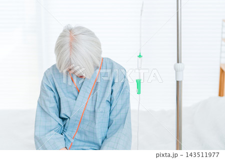病気の宣告を受け病室のベッドで俯く,泣く,絶望する高齢者の入院患者 病気の宣告を受け病室のベッドで俯く,泣く,絶望する高齢者の入院患者 143511977