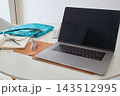 Doctor workspace with laptop, stethoscope, and scrubs 143512995