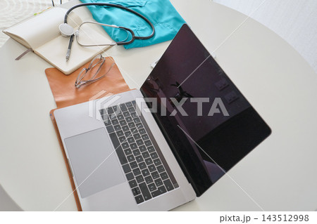 Medical professional workstation with laptop, stethoscope, and notebook 143512998