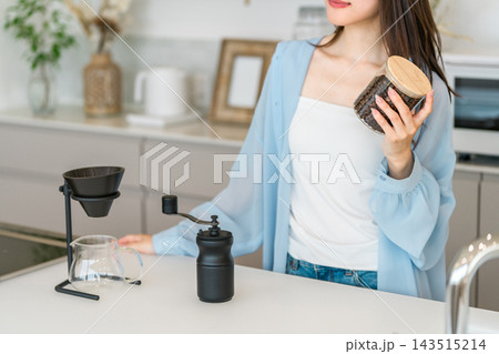 自宅のキッチンでコーヒーミルでコヒー豆を挽くアジア人女性 143515214