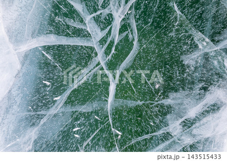 Deep turquoise cracked ice texture of frozen Lake Baikal in winter 143515433