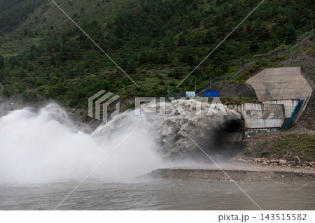 Hydroelectric power station spillway releasing water torrent in mountains 143515582