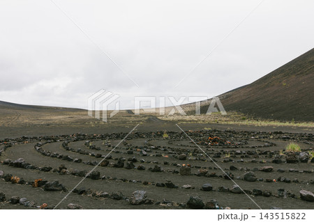 Stone spiral labyrinth on dark volcanic ash ground in Kamchatka Stone spiral labyrinth on dark volcanic ash ground in Kamchatka 143515822