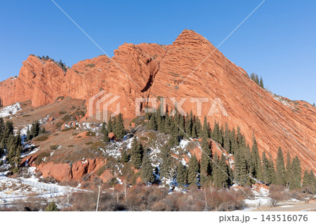 Red sandstone mountain formation at Jeti Oguz gorge against a clear blue sky 143516076