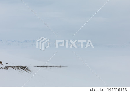 Mountain road covered in snow and dense fog at Ala-Bel Pass in winter Mountain road covered in snow and dense fog at Ala-Bel Pass in winter 143516158