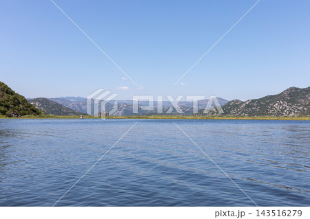 Scenic view of tranquil waters and mountains at Lake Skadar in Virpazar 143516279