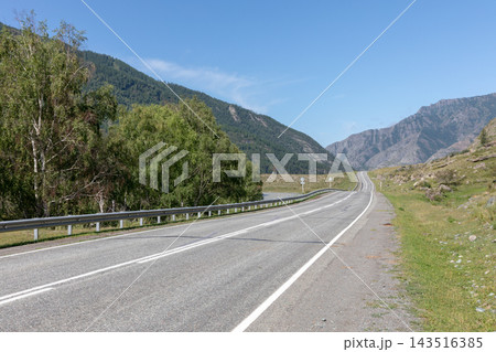 Scenic asphalt highway winding through picturesque mountains on a sunny day Scenic asphalt highway winding through picturesque mountains on a sunny day 143516385