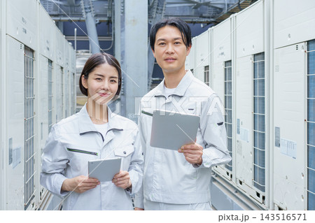 タブレットを持ってビルのメンテナンスをする若い日本人の男女2人のポートレート 143516571