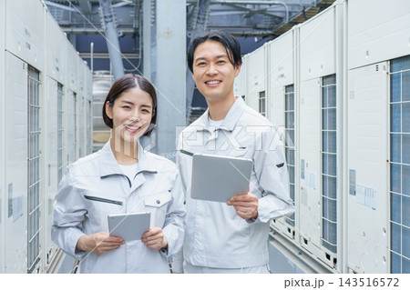 タブレットを持ってビルのメンテナンスをする若い日本人の男女2人のポートレート 143516572
