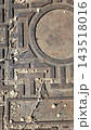 Old metal manhole cover on asphalt texture close up 143518016