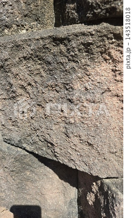 Rough textured ancient stone wall surface close up Rough textured ancient stone wall surface close up 143518018