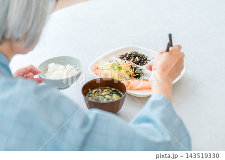 病院で栄養バランスの取れた病態食を食べる入院患者の高齢者女性 病院で栄養バランスの取れた病態食を食べる入院患者の高齢者女性 143519330