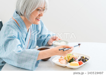 病院でカロリー計算のされた病態食を食べる車椅子に乗った入院患者のシニア女性 病院でカロリー計算のされた病態食を食べる車椅子に乗った入院患者のシニア女性 143519497