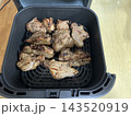 ノンフライヤーで焼き上げた豚スペアリブの調理風景 143520919