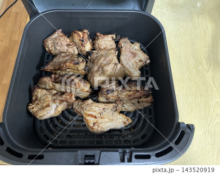 ノンフライヤーで焼き上げた豚スペアリブの調理風景 143520919