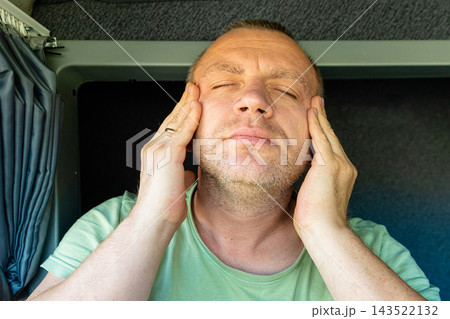 Tired man rubbing his temples with closed eyes suffering from migraine 143522132