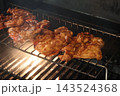 炎で香ばしく焼ける味付けチキンのBBQ 143524368