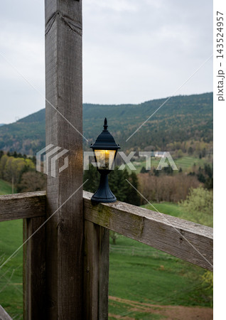Rural landscape with beacon light over countryside fields. Gentle beacon light illuminating peaceful rural countryside at dusk with green fields stretching to distant hills, atmospheric evening landsc 143524957