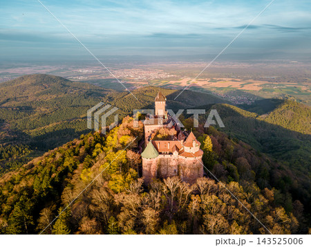 Evening golden light bathing medieval ramparts and towers. Castle Haut-Koenigsbourg, Alsace, France - April 10, 2026 - Evening golden light bathing medieval ramparts and towers, warm tones accentuatin Evening golden light bathing medieval ramparts and towers. Castle Haut-Koenigsbourg, Alsace, France - April 10, 2026 - Evening golden light bathing medieval ramparts and towers, warm tones accentuatin 143525006