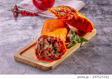 Wooden board, red tortilla chicken shawarma wraps with vegetables and basil leaf, Middle Eastern street food 143525282