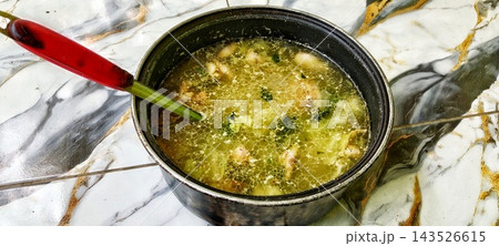 Chicken soup with broccoli in a black pot 143526615