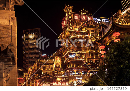 Traditional Chinese architecture illuminated at night with vibrant lanterns and modern skyscrapers in the background, showcasing a blend of old and new urban design Traditional Chinese architecture illuminated at night with vibrant lanterns and modern skyscrapers in the background, showcasing a blend of old and new urban design 143527859