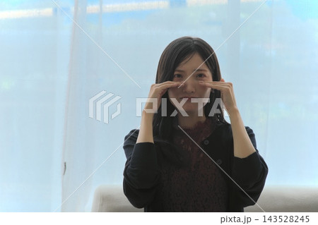 窓際で目元を手で覆い泣き顔を見せる若い女性(悲しい・ショック・涙・お悩みイメージ) 窓際で目元を手で覆い泣き顔を見せる若い女性(悲しい・ショック・涙・お悩みイメージ) 143528245