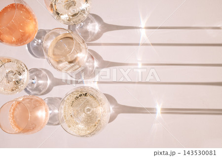 A close-up of elegant glasses with alcoholic beverages. Cups with colorful sparkling wines from different grape varieties. Champagne goblets on a white background. Top of view. A close-up of elegant glasses with alcoholic beverages. Cups with colorful sparkling wines from different grape varieties. Champagne goblets on a white background. Top of view. 143530081