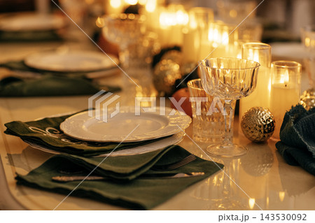 A cozy stylish living room with a covered table and a decorated Christmas tree with a garland. A cozy stylish living room with a covered table and a decorated Christmas tree with a garland. 143530092