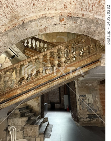 Historic stone staircase beneath weathered arched ceiling in restored European building interior Historic stone staircase beneath weathered arched ceiling in restored European building interior 143530282