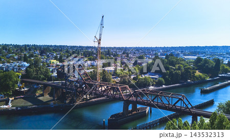 Aerial Train Bridge and Construction Crane Over Waterway in Seattle Aerial Train Bridge and Construction Crane Over Waterway in Seattle 143532313
