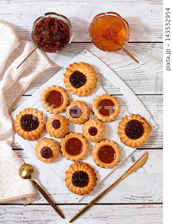 Freshly baked homemade shortbread cookies with jam and preserves on wooden background, modern bakery and grain based product concept. Healthy breakfast with ingredients, cafe and restaurant menu, Freshly baked homemade shortbread cookies with jam and preserves on wooden background, modern bakery and grain based product concept. Healthy breakfast with ingredients, cafe and restaurant menu, 143532954
