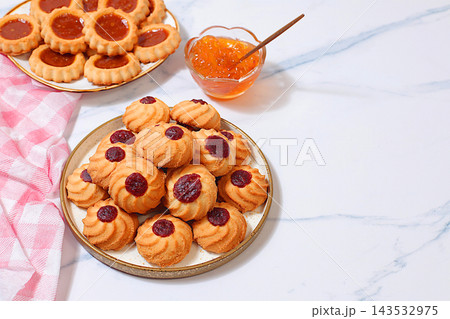 Homemade shortbread cookies with jam and preserves on a marble background, concept for modern baking and grain based treats. An idea for a healthy breakfast a cafe or restaurant menu or template Homemade shortbread cookies with jam and preserves on a marble background, concept for modern baking and grain based treats. An idea for a healthy breakfast a cafe or restaurant menu or template 143532975