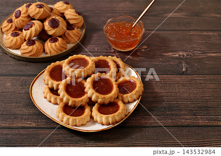 Assorted homemade shortbread cookies with jam and preserves on wooden background concept representing modern baked goods and grain based treats. An idea for a wholesome breakfast a cafe menu Assorted homemade shortbread cookies with jam and preserves on wooden background concept representing modern baked goods and grain based treats. An idea for a wholesome breakfast a cafe menu 143532984
