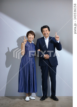 おしゃれをして笑顔で寄り添う60代の夫婦 おしゃれをして笑顔で寄り添う60代の夫婦 143536158