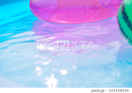 ピンクの浮き輪とビーチボールのある夏の水面 143539254
