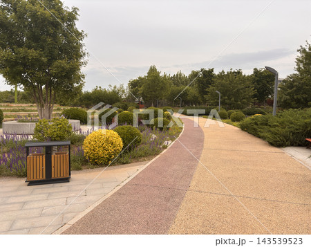 Scenic landscaped garden in Beijing with colorful flower beds, rounded ornamental shrubs Scenic landscaped garden in Beijing with colorful flower beds, rounded ornamental shrubs 143539523