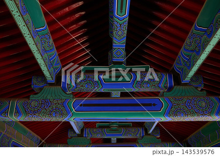 Symmetrical view of painted wooden beams at the Temple of Heaven in Beijing, China. 143539576