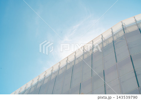 青空を背景に見上げた建物の白い外壁 143539790